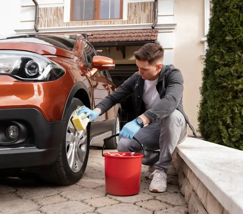 Lavage auto à domicile Chazey-sur-Ain : professionnel intervenant sur un véhicule